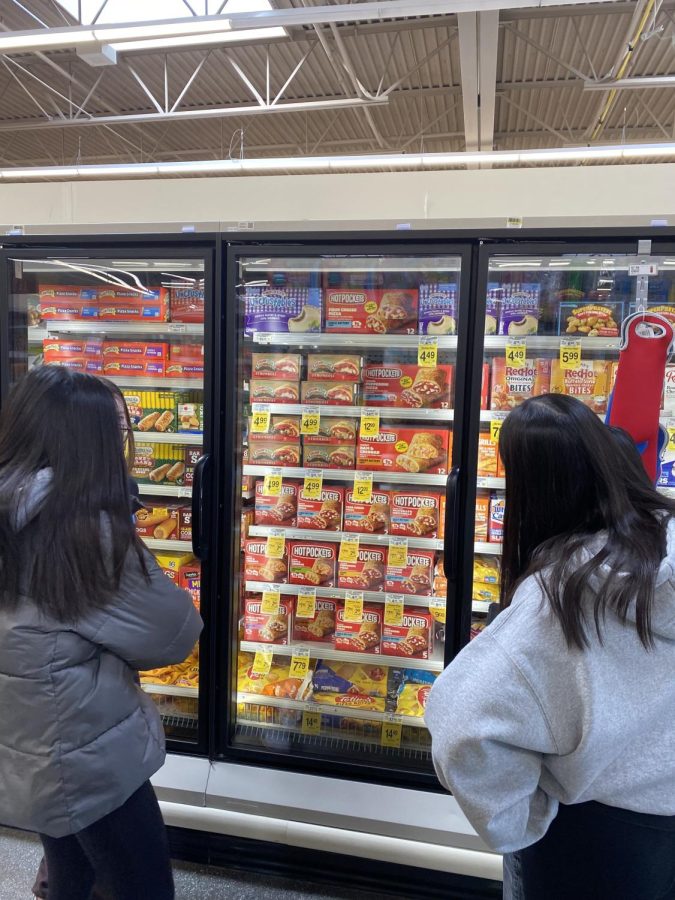 Scouring through Safeways freezers, Sam,  Sophia, Karina, and Sally ponder which of the repulsive flavors to try.