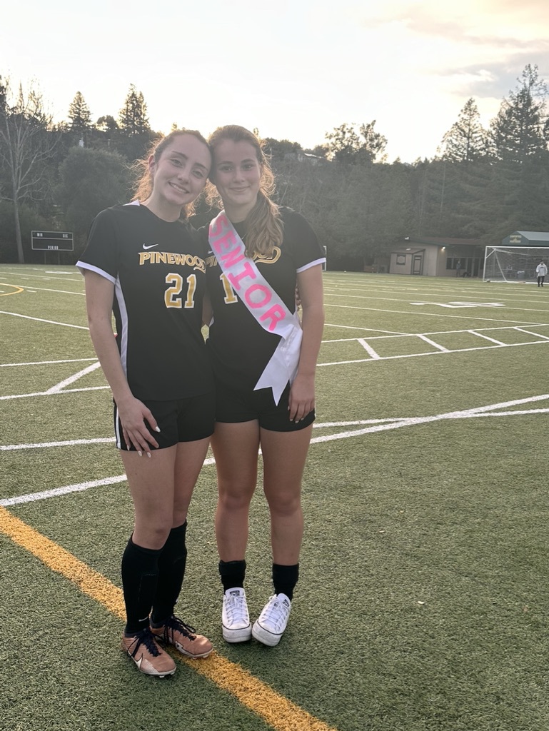 Violet and Charlotte posing for a picture at Senior Night
